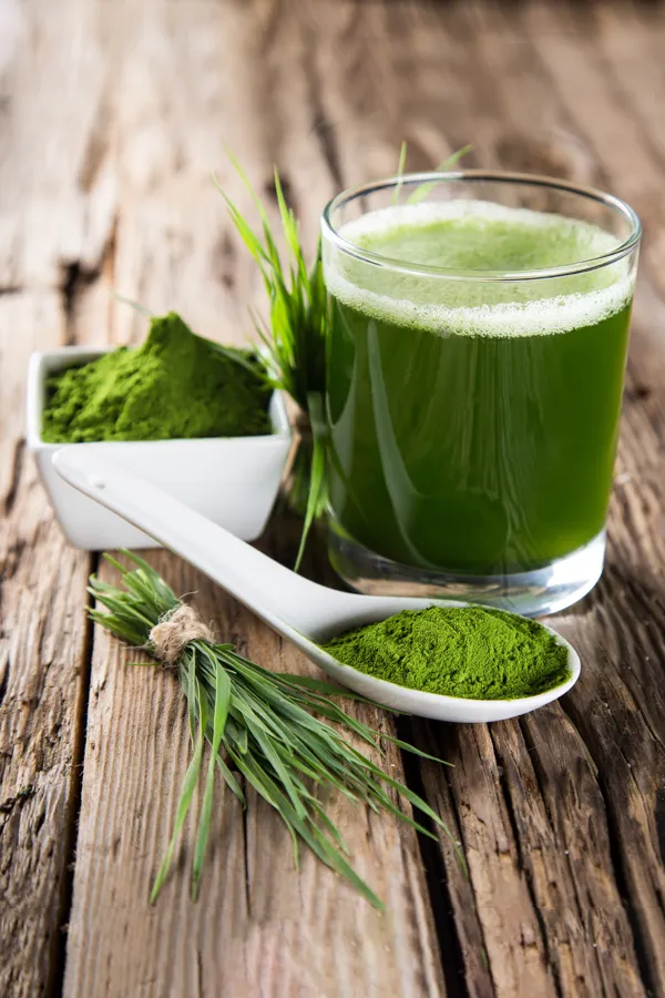 Chelation-and-Detoxification-Treatment Close-up of healthy greens and green powders and a glass of green juice on a rustic wood table. Get chelation and detoxification treatment from Allen Green, M.D. of Center for Optimum Health in Los Angeles.