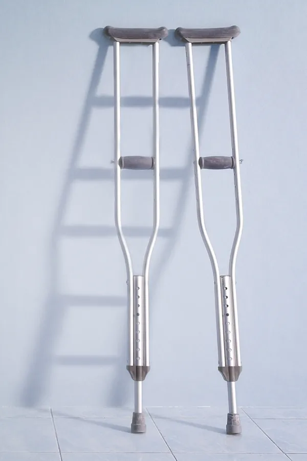 A pair of crutches rest against a gray wall, representing peptide therapy for healing and recovery from Allen Green, M.D. of Center for Optimum Health in Los Angeles.