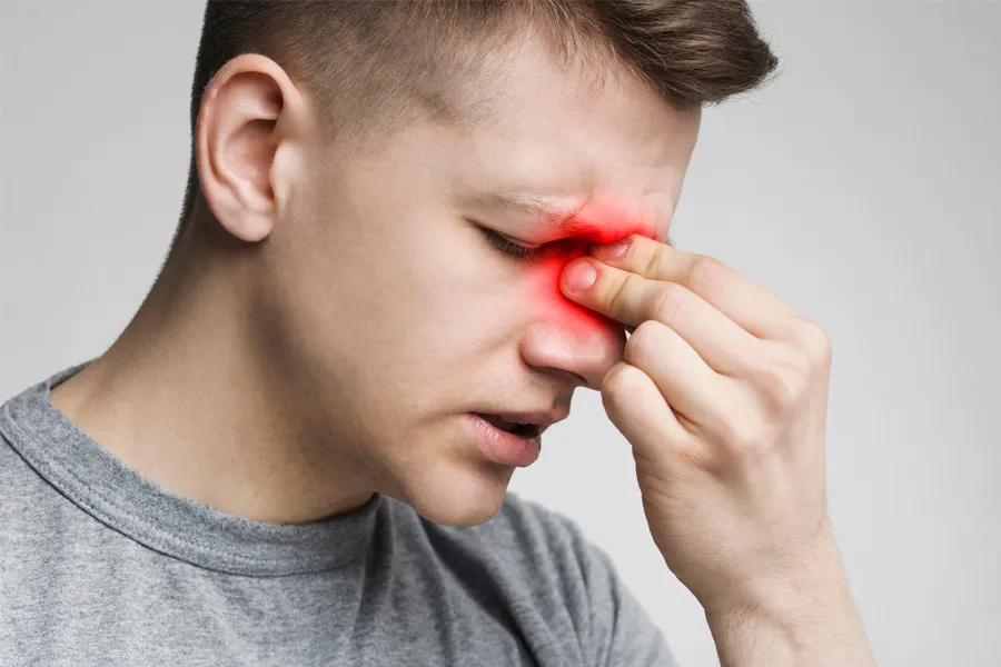 Sinus-Infection-Clinic A man grimaces and rubs the bridge of his nose due to sinus irritation. Get treatment for sinus infections from Allen Green, M.D. of Center for Optimum Health in Los Angeles.